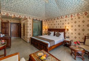 a bedroom with a large bed in a room at Bijainagar Fort in Jāmb +21 photos