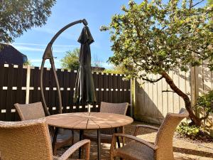 a patio table with chairs and an umbrella at K4 Wohnung mit Gartenblick in Jever