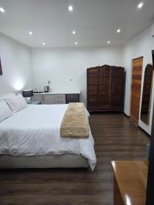 a bedroom with a large white bed and wooden floors at 47 Northward BnB in Newcastle +26 photos