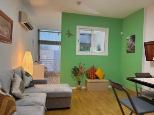 a living room with green walls and a couch at Villaverde light & terrace in Madrid