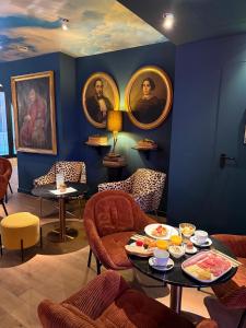 a blue room with portraits on the wall and a table at Aparthotel Casa Fages by Fimedhotels in Figueres