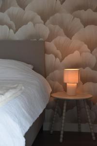 a table with a lamp next to a bed at Bed & Bresjes in Breskens +2 photos