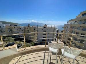 a balcony with two chairs and a view of the ocean at Sea Gate Apartments in Sarandë
