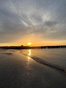a sunset on a beach near the water at Bed & Bresjes in Breskens