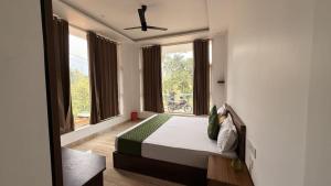 a bedroom with a bed in a room with windows at Uforia Munnar in Munnar +18 photos