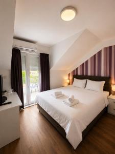a bedroom with a large white bed and a window at VilaMihaela in Skopje +39 photos