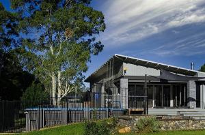 a house with a fence in front of it at Jasmine Escape SPA Pool Secluded Bush Views in Ellalong