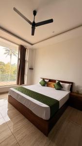 a bedroom with a large bed with a ceiling fan at Uforia Munnar in Munnar