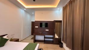 a hotel room with a bed and a television in it at Uforia Munnar in Munnar