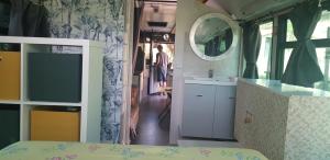 a room with a bed and a sink and a mirror at Bus aménagé in Millas