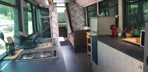 a kitchen with a stove and a refrigerator in a tiny house at Bus aménagé in Millas