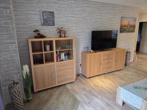 a living room with a television on a wooden entertainment center at Haus Küstenheide in Cuxhaven