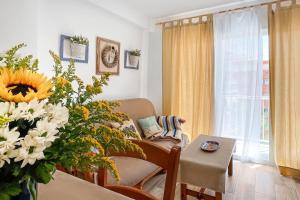 a living room with a couch and a vase of flowers at Azul. Cómodo, bonito y céntrico in Calpe