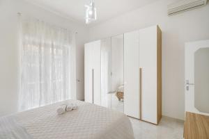 a white bedroom with a bed and a large window at Angel's House in Sarno