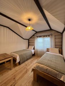 two beds in a room with a ceiling at Наше Місце in Krymno