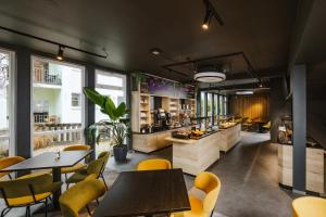 a restaurant with tables and yellow chairs in a room at Hostel SLEPS in Augsburg