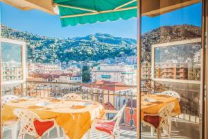 a balcony with tables and chairs and a view of a city at MARI E MONTI Appartamento centrale con vista panoramica in Rapallo
