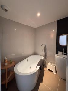 a white bath tub in a bathroom with a toilet and a sink at La Maison des Eléphants in Vivonne +37 photos