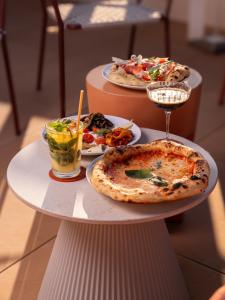 three plates of pizza and drinks on a table at Hôtel Liautaud Cassis by Germain Collection in Cassis