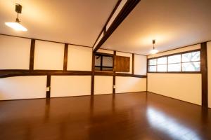 an empty room with a wooden floor and a large window at 青木邸 in Tokushima