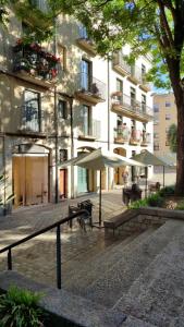 a courtyard with tables and umbrellas in front of a building at Hostal Milana Girona in Girona