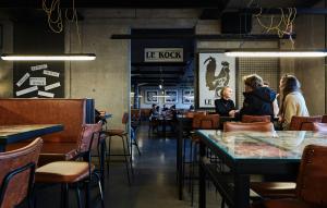a group of people sitting at tables in a restaurant at Exeter Hotel in Reykjavík
