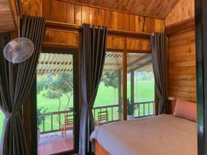 a bedroom with a bed and a large window at Mai Chau Mountain Delight in Mai Châu +39 photos