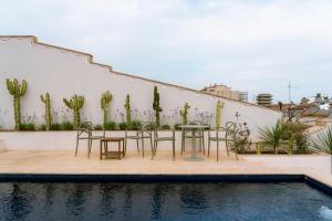 a patio with chairs and a table next to a pool at Aparthotel Casa Fages by Fimedhotels in Figueres