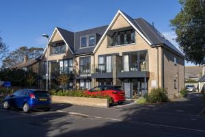 a house with two cars parked in front of it at Seashells in Highcliffe