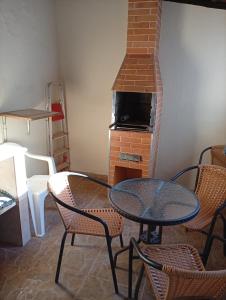 a room with a table and chairs and a fireplace at Quarto Suite & Cozinha in Piraju