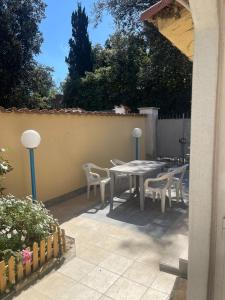 a patio with a table and chairs and a fence at Apartment with garden PERLA NERONIANA in Anzio