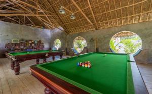 a billiard room with a pool table and two windows at Legendary Zanzibar Beach Resort in Michamvi