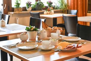 a wooden table with plates and cups on it at Pension Schöpke in Bad Staffelstein