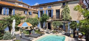 a courtyard with a swimming pool in front of a building at Logement Onze Chambres & Gîtes in Raissac-dʼAude
