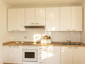 a white kitchen with white cabinets and a sink at Apartment Tinca by Interhome in Domaso