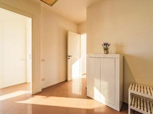 a hallway with a white cabinet with a plant on top at Apartment Tinca by Interhome in Domaso