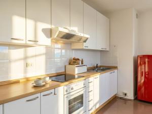 a kitchen with white cabinets and a red refrigerator at Apartment Tinca by Interhome in Domaso