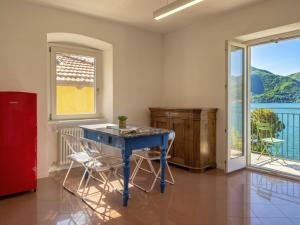 a blue table and chairs in a room with a window at Apartment Tinca by Interhome in Domaso +21 photos