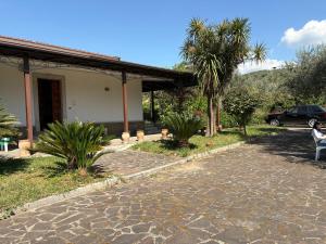 a person sitting on a bench in front of a house at Villa Filomena in Montoro Inferiore