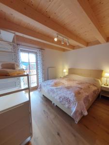 a bedroom with a bed and a large window at Almchalet Schweigerbuam Lachtal in Hinteralm +4 photos