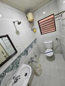 a bathroom with a sink and a toilet and a mirror at Hotel Gazala in Palakkad