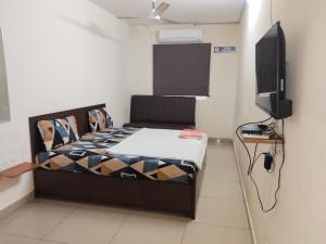a bedroom with a bed and a flat screen tv at AB Merridien in Coimbatore