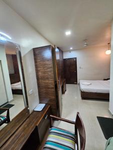 a room with a bedroom with a bed and a chair at Hotel Gazala in Palakkad +6 photos