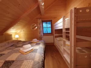a bedroom with a bed and bunk beds in a cabin at Almchalet Schweigerbuam Lachtal in Hinteralm