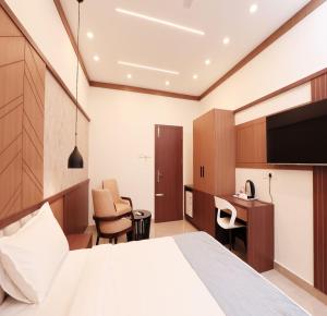a hotel room with a bed and a desk at AdaraResidency in Trivandrum