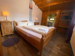 a bedroom with a large bed with a wooden floor at Gasthaus Goa in Ernsthausen