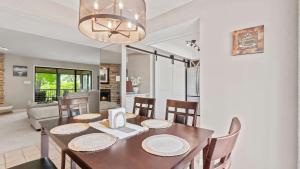 a dining room and living room with a table and chairs at Lake Ozark Oasis Central Location & Pool Access in Lake Ozark +26 photos