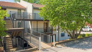 a building with stairs and a tree in front of it at Lake Ozark Oasis Central Location & Pool Access in Lake Ozark