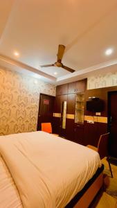 a bedroom with a large white bed with orange chairs at Hotel Crystal Inn in Lucknow