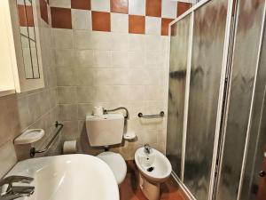a bathroom with a toilet and a sink and a shower at Apartment Mairen-3 by Interhome in Rosolina Mare